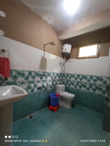 a bathroom with a toilet and a sink at Tirthan river edge in Bathād