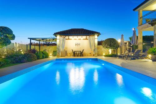 a swimming pool in a backyard with a gazebo at Villa Morgan by Rent Istria in Umag