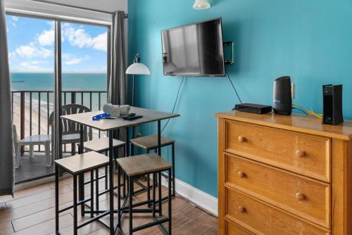 a room with a table and a balcony with the ocean at The Palace 2306 in Myrtle Beach