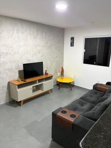 a living room with a couch and a tv at Apartamento com vista e privacidade , ideal para casais , próximo da praia in Rio de Janeiro