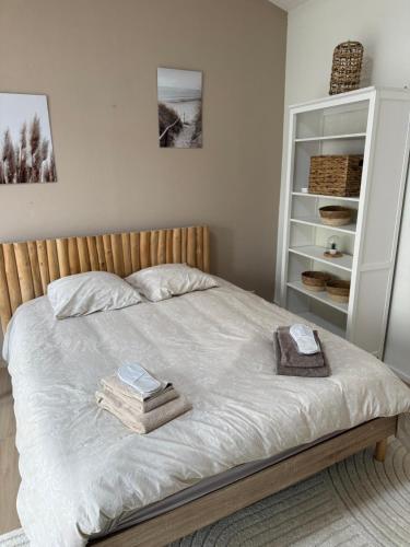 a bedroom with a bed with two towels on it at Le havre des embruns in Saint-Xandre