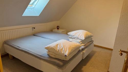 a bedroom with a bed with white sheets and pillows at Holiday Apartment Rudkøbing in Rudkøbing