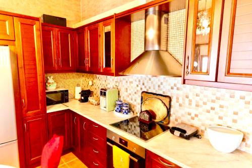 a kitchen with wooden cabinets and a counter top at VillaAnna in Keratea