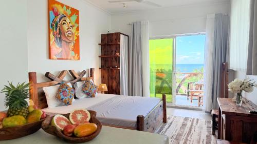 a bedroom with a bed with a bowl of fruit on a table at Zanziland Apartments in Kiwengwa