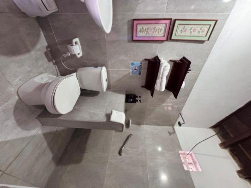a bathroom with a toilet and towels on the wall at Casa colonial Centro Histórico - Puerta Azul in Mompos