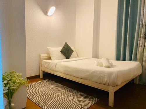 a bedroom with a bed with white sheets and pillows at London Guest House in Caneças