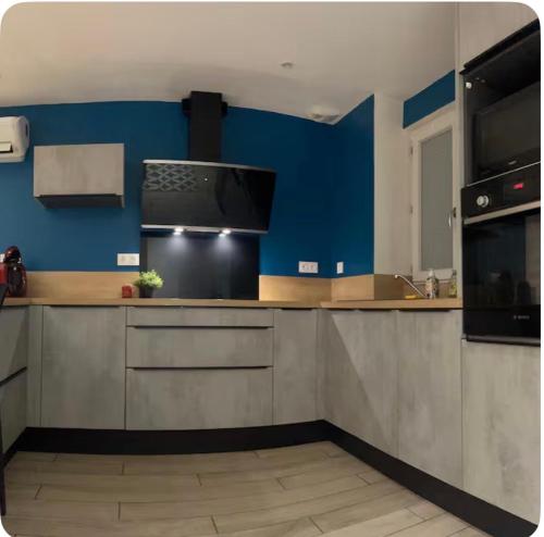 a kitchen with blue walls and a counter top at La maysou in Ussel