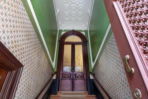 a hallway with a wooden door in a building at Casa do Arquiteto Townhouse - Adults Only in Porto