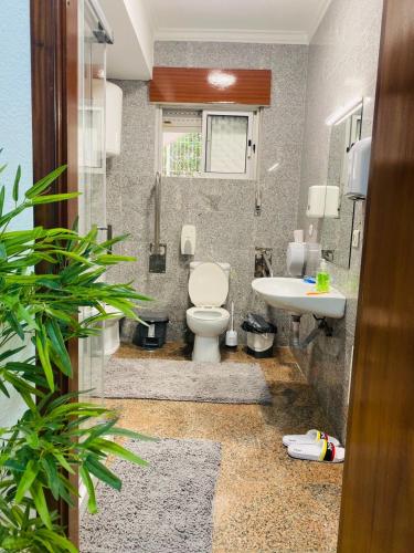 a bathroom with a toilet and a sink at London Guest House in Caneças