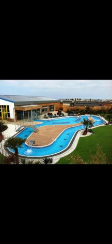 a large swimming pool in front of a building at 1 The Willows Reighton Sands in Reighton