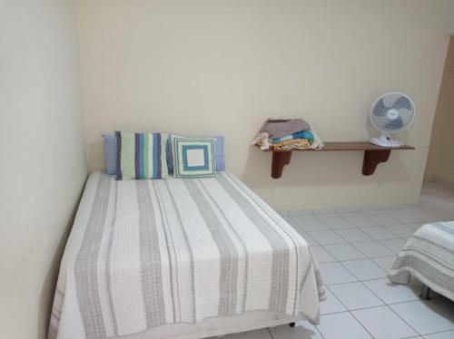 a bedroom with a bed with a striped blanket at Refugio na Serra 2 in Bananeiras