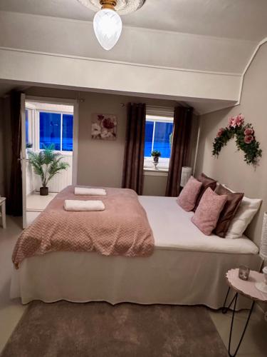 a bedroom with a large bed and two windows at Villa Utsikten Kirketaket in Åndalsnes