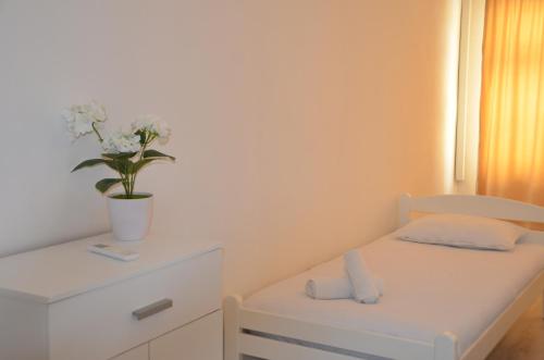 a small bedroom with a bed with a plant on it at Apartman San in Mostar