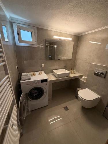 a bathroom with a washing machine and a sink at Casa al mare Anastasia in Nea Kallikrateia