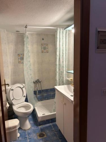 a bathroom with a toilet and a tub and a sink at Evgenias Beach Escape in Kallithea Halkidikis