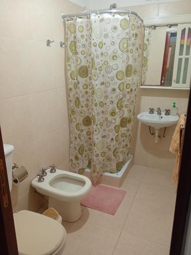 a bathroom with a toilet and a shower curtain at La Tranquila in Fernández