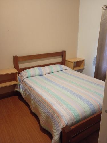 a bedroom with a bed with a striped comforter at La Tranquila in Fernández