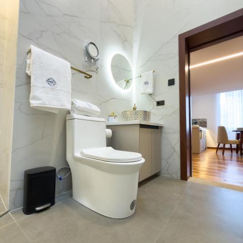 a white bathroom with a toilet and a sink at Arbórea Casa Boutique in Cuenca