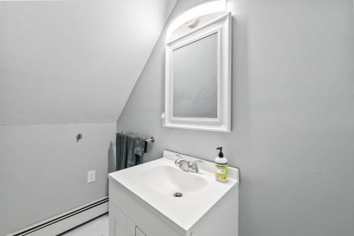 a white bathroom with a sink and a mirror at Cabot Modern Pet Friendly Apt 2nd Floor Studio in Whitefield