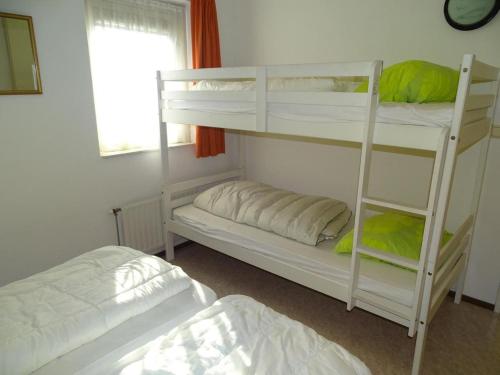 a bedroom with two bunk beds and a window at Bungalow in Breskens near Beach and Lighthouse in Breskens