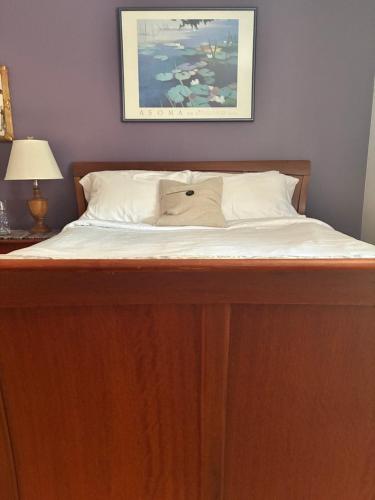 a bed with white sheets and a pillow on it at Lawrence Loft in Lawrence