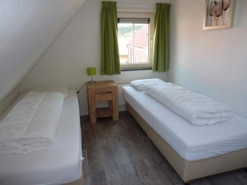 two beds in a room with a window at Holiday Home Breskens near the Coast in Breskens