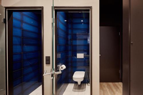 baño con aseo y paredes azules en The Loft Budapest, en Budapest