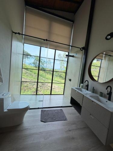 a bathroom with two sinks and a large window at CASALIA Sopetran in Sopetrán