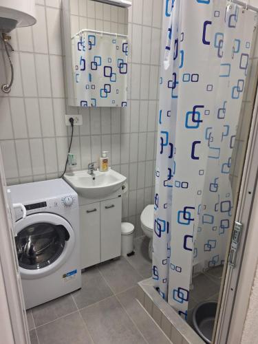 a bathroom with a washing machine and a sink at Apartmani Ksenija Sofija in Igalo