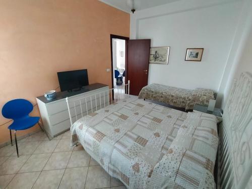 a bedroom with two beds and a television in it at The sisters apartment in Punta Marina