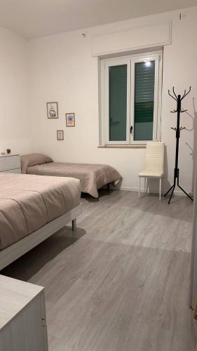 a white room with two beds and a window at Bilocale a 300m dal mare e 100m fermata filobus in Pescara