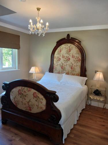 a bedroom with a large bed and a chandelier at Sheiling Accommodation in Castlemartyr