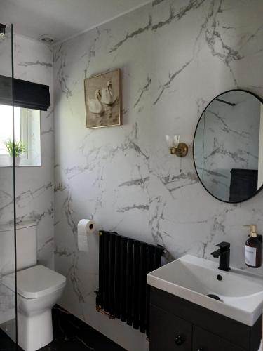 a white bathroom with a sink and a mirror at Sheiling Accommodation in Castlemartyr