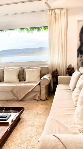 a living room with a couch and a large window at Cabanas da Auga B in Casas Novas