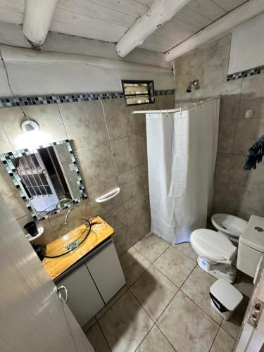 a bathroom with a sink and a toilet and a mirror at Casita siempre verde in Los Hornillos