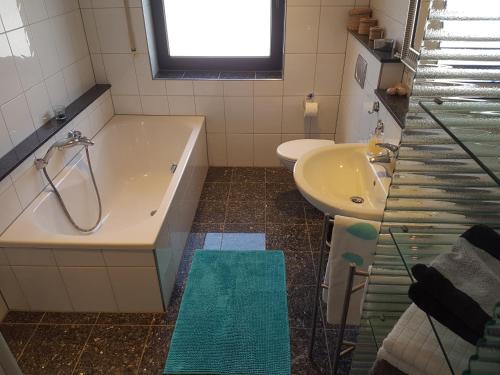 a bathroom with a tub and a sink at Ferienunterkünfte Deinhardt in Poxdorf