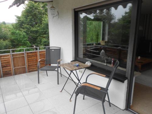 a balcony with chairs and a table and a window at Ferienunterkünfte Deinhardt in Poxdorf