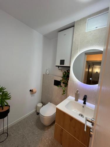 a bathroom with a toilet and a sink and a mirror at Lena Apartment in Calafat