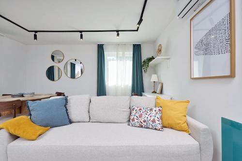 a living room with a white couch with colorful pillows at Villa Balaton in Balatonmáriafürdő