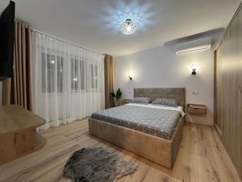 a bedroom with a bed and a chandelier at Lena Apartment in Calafat