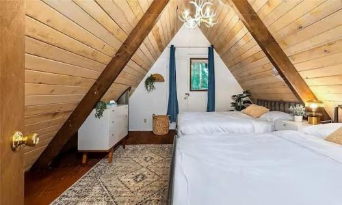 ein Schlafzimmer im Dachgeschoss mit zwei Betten und einem Kronleuchter in der Unterkunft Tiny Timber in Packwood
