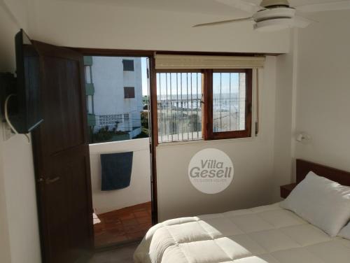 a bedroom with a bed and a window at Bright beachfront apartment with ocean view in Villa Gesell