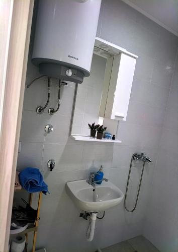 a white bathroom with a sink and a mirror at Vila Lana in Trebinje