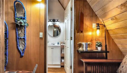 ein Flur mit einem Spiegel und einem Waschbecken in einem Zimmer in der Unterkunft Tiny Timber in Packwood