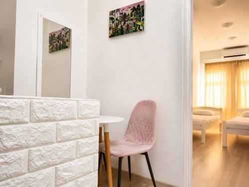 a room with a pink chair and a table at Apartman San in Mostar