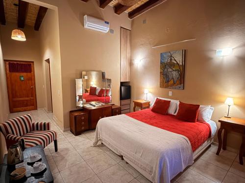 a bedroom with a large bed and a chair at Posada Cavieres Wine Farm in Maipú