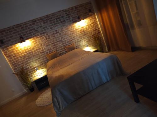 a bedroom with a bed and a brick wall at 1904 Studio in Świnoujście