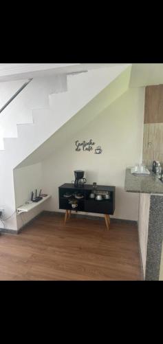 a living room with a white wall with a table at COBERTURA Duplex 302,vista d Mar e piscina in Piúma