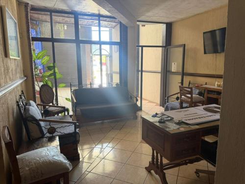 a living room with a desk and a room with a window at Hotel Casa Zaragoza, San Juan de los Lagos in San Juan de los Lagos