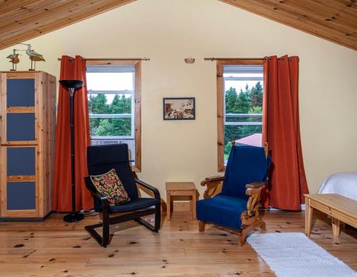 a room with two chairs and a bed and windows at Spa Stukely in Eastman